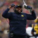 O técnico Sherrone Moore do Michigan Wolverines reage na linha lateral durante o primeiro quarto contra o Ohio State Buckeyes no Michigan Stadium em 29 de novembro de 2025 em Ann Arbor, Michigan.
