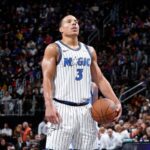 O jogador do Orlando Magic, Wendell Carter Jr., segura a bola de basquete durante as quartas de final da Emirates NBA Cup. Desmond Bane # 3 do Orlando Magic arremessa uma cesta contra o Miami Heat no segundo tempo de um jogo das quartas de final da Emirates NBA Cup no Kia Center em 09 de dezembro de 2025 em Orlando, Flórida.