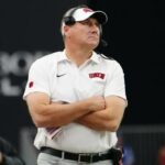 O técnico do UNLV Rebels, Dan Mullen, observando do lado de fora.