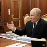 Um militar russo está ao lado dos restos de um drone que, segundo o Ministério da Defesa russo, foi abatido durante a repulsão de um suposto ataque ucraniano à residência presidencial russa na região de Novgorod