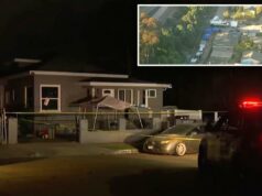 Restos humanos enterrados em uma casa ligada a um homem atualmente preso por um assassinato em 2023 Uma vista aérea mostra investigadores em trajes brancos de proteção e um policial trabalhando na cena do crime.