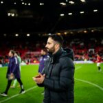 Matheus Cunha holds Manchester United badge.