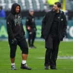 O técnico Nick Sirianni do Philadelphia Eagles fala com Saquon Barkley #26 durante o aquecimento antes do jogo contra o Las Vegas Raiders no Lincoln Financial Field em 14 de dezembro de 2025 na Filadélfia, Pensilvânia.