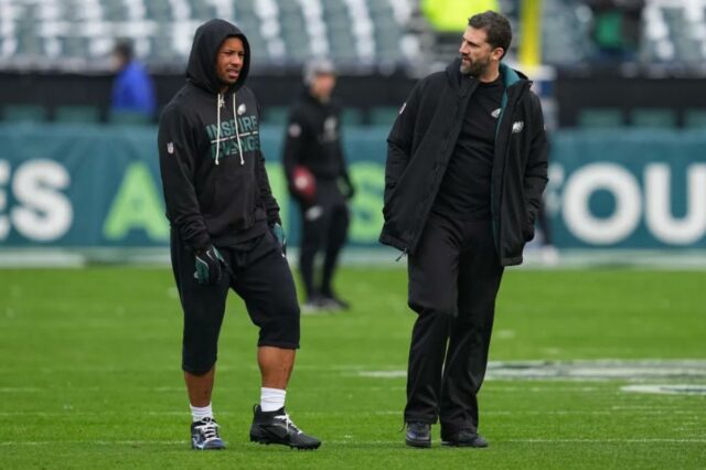 O técnico Nick Sirianni do Philadelphia Eagles fala com Saquon Barkley #26 durante o aquecimento antes do jogo contra o Las Vegas Raiders no Lincoln Financial Field em 14 de dezembro de 2025 na Filadélfia, Pensilvânia. 