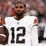 Shedeur Sanders #12 of the Cleveland Browns stands on the sidelines during the national anthem.