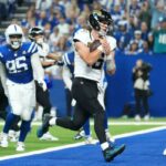 O quarterback do Jacksonville Jaguars, Trevor Lawrence, marca o ataque defensivo do Indianapolis Colts, Adetomiwa Adebawore (95) e o safety Camryn Bynum (0), durante o segundo tempo de um jogo de futebol americano da NFL no domingo, 28 de dezembro de 2025.