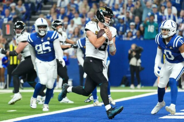 O quarterback do Jacksonville Jaguars, Trevor Lawrence, marca o ataque defensivo do Indianapolis Colts, Adetomiwa Adebawore (95) e o safety Camryn Bynum (0), durante o segundo tempo de um jogo de futebol americano da NFL no domingo, 28 de dezembro de 2025.