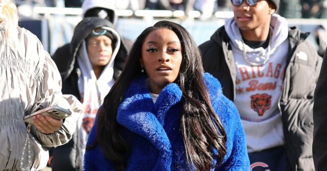 Simone Biles permanece aquecida com casaco peludo personalizado para o Simone Biles permanece aquecida com casaco peludo personalizado para o jogo dos ursos do marido