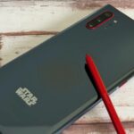 Um Samsung Galaxy Note 9 e um Galaxy S25 Ultra lado a lado em um azulejo florido com um pelúcia azul