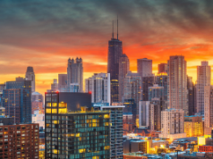 Sports Betting Alliance processa Chicago por novo plano tributário e de licenciamento A Sports Betting Alliance processa Chicago por causa do novo plano tributário e de licenciamento. Horizonte de Chicago ao pôr do sol com arranha-céus iluminados, incluindo o John Hancock Center, brilhando contra um céu laranja e azul.