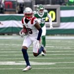 O wide receiver do Patriots, Stefon Diggs (8), corre com a bola no campo.