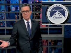 Stephen Colbert argumenta que a oferta de US$ 108 bilhões da Paramount pela Warner Bros prova que a rede ‘pode se dar ao luxo de cancelar’ seu programa Stephen Colbert de terno gesticulando com a mão esquerda em frente ao horizonte da cidade.