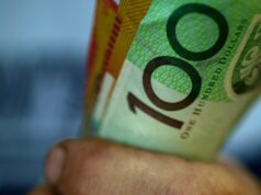 Surpresa culpada forçando australianos à falência Alguém segurando um punhado de notas de US$ 50 e US$ 100.