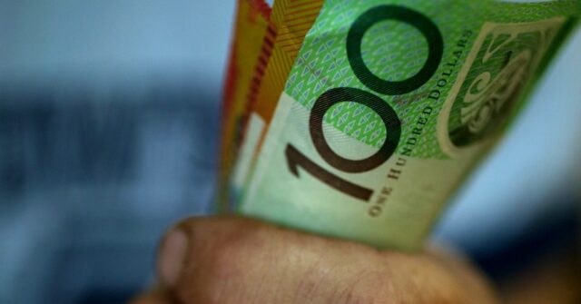 Surpresa culpada forçando australianos à falência Alguém segurando um punhado de notas de US$ 50 e US$ 100.