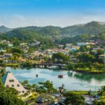 Linda praia de areia branca em Santa Lúcia com cenário montanhoso.