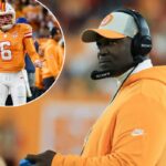 Todd Bowles com um chapéu branco e laranja e um moletom laranja assistindo ao jogo.