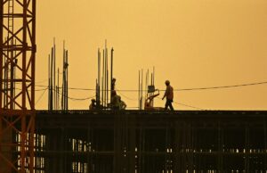 Trabalhadores da construção civil estão lucrando com o boom da IA Men work at under construction site in New Delhi
