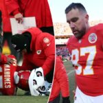 Travis Kelce, vestindo uma camisa vermelha do Kansas City Chiefs com o número 87, sai do campo após perder um jogo.