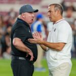 College football head coach Mark Stoops of the Kentucky Wildcats talks with head coach Shane Beamer of the South Carolina Gamecocks