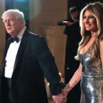 Donald e Melania Trump caminham juntos de mãos dadas.