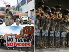 Trump retirando a Guarda Nacional de Chicago, Portland e Los Angeles – avisa ‘vamos voltar’ Membro armado da Guarda Nacional em uniforme camuflado, usando capacete com viseira transparente, em pé com um rifle do lado de fora do Edifício Federal Edward Roybal, em Los Angeles, com pichações visíveis.