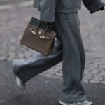 BERLIM, ALEMANHA - 25 DE NOVEMBRO: Laura Noltemeyer é vista vestindo um cardigã de malha bouclé com textura creme e silhueta estruturada e fecho de botão dourado da Massimo Dutti; calça jeans reta azul claro com desbotamento suave em corte clássico da Zara; botas plataforma de couro marrom escuro e cinza com detalhes em monograma e sola de borracha grossa e detalhes em camurça da Louis Vuitton; uma bolsa de couro branco estruturado com alça superior em tecido intrecciato e silhueta trapézio chamada “Intrecciato Tote” da Bottega Veneta; brincos grossos de ouro escultural da Zara; seu cabelo castanho escuro está solto, liso e repartido ao meio em 25 de novembro de 2025 em Berlim, Alemanha. (Foto de Moritz Scholz/Getty Images)