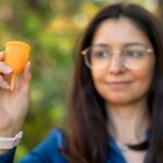 Uma mulher com um traje espacial azul flutua na cabine de um ônibus espacial.
