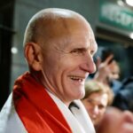 Uma mulher segura uma antiga bandeira da Bielorrússia enquanto espera prisioneiros libertados na embaixada dos EUA em Vilnius, Lituânia.