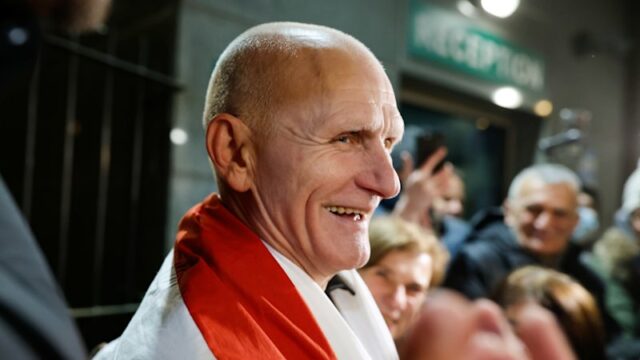 Vencedor do Prêmio Nobel da Paz, importantes figuras da oposição Uma mulher segura uma antiga bandeira da Bielorrússia enquanto espera prisioneiros libertados na embaixada dos EUA em Vilnius, Lituânia.