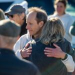 Pessoas presentes no memorial de Erica Fox, 55, cofundadora do grupo de natação em águas abertas Kelp Krawlers, caminham ao longo da costa perto de onde Fox normalmente nadaria em Pacific Grove, Califórnia, no domingo, 28 de dezembro de 2025. O corpo de Fox foi recuperado por bombeiros em uma praia ao sul de Davenport ontem, uma semana depois que ela desapareceu enquanto nadava no domingo, 21 de dezembro, perto de Lovers Point, na época em que um avistamento de tubarão foi relatado. (Doug Duran/Grupo de Notícias da Bay Area)