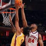 Lamin Sabally do Iona Gaels chuta a bola enquanto Zuby Ejiofor do St. John's Red Storm o defende.