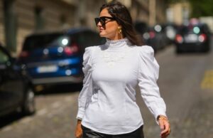 17 blusas de aparência cara que visualmente estreitam um top de muffin Amanda Mühle é vista vestindo um casaco de lã cinza com lapelas largas, fecho de botão e gola abotoada da Siyazu; um suéter de malha estampado em tom suave de verde e rosa com padrão argyle e textura de mistura de lã macia da Marc O'Polo Denim; uma camiseta branca de algodão da COS usada por baixo; jeans azul com corte reto e solto da Zara; botas Mou de camurça bege com sola plataforma e detalhes costurados exclusivos da Mou; uma “bolsa City” Balenciaga de couro rosa com formato suavemente desleixado, alças superiores e detalhes prateados da Balenciaga; vários anéis de prata da Pilgrim; segurando uma revista Vogue; óculos estilo aviador com armação rosa e lentes levemente coloridas da Lexxola; brincos de prata com acabamento escultural da Mango; seus longos cabelos castanhos estão soltos e repartidos de lado em 8 de janeiro de 2026 em Munique, Alemanha.