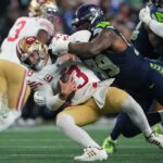 O quarterback do San Francisco 49ers, Brock Purdy, reage após perder a bola durante o segundo tempo de um jogo de playoff da divisão de futebol da NFL contra o Seattle Seahawks, sábado, 17 de janeiro de 2026, em Seattle. (Foto AP/Stephen Brashear)