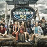 A group of peoplein a tropical envrioment in front of a sign that reads 'Survivor 50'