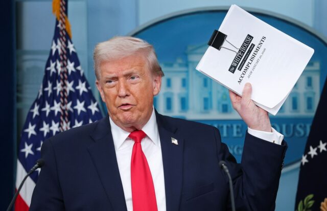 71 por cento dos americanos dizem que os EUA estão Donald Trump displays a stack of papers labeled