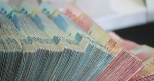 A Apple foi multada em um total de US$ 851 milhões no ano passado por violações de privacidade e antitruste | A foto mostra grandes pilhas de notas