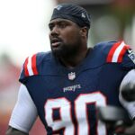 Christian Barmore se aquecendo com o uniforme do Patriots.