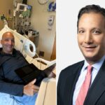 Um homem sorrindo em uma cama de hospital enquanto usa um laptop.