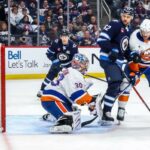 Os jogadores do Winnipeg Vladislav Namestnikov (7) e Nino Niederreiter (62) observam enquanto o disco fica atrás do goleiro Ilya Sorokin para um gol no segundo período durante a derrota dos Islanders por 5-4 para os Jets em 13 de janeiro de 2025.