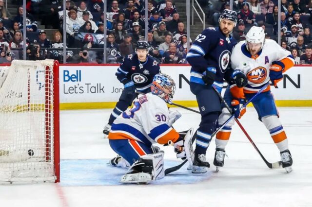 Os jogadores do Winnipeg Vladislav Namestnikov (7) e Nino Niederreiter (62) observam enquanto o disco fica atrás do goleiro Ilya Sorokin para um gol no segundo período durante a derrota dos Islanders por 5-4 para os Jets em 13 de janeiro de 2025.