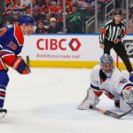 O goleiro do New York Islanders, Ilya Sorokin (30), faz uma defesa contra um chute do atacante do Edmonton Oilers, Zach Hyman (18), durante o primeiro período em Rogers Place.