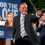 Rick Caruso comemorando em sua reunião da noite das primárias com sua família atrás dele.