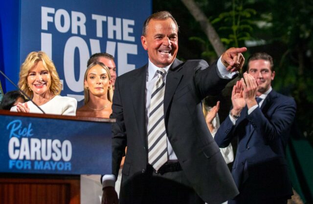 Rick Caruso comemorando em sua reunião da noite das primárias com sua família atrás dele.