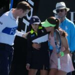 Zeynep Sonmez da Turquia e o árbitro Chase Urban ajudam um garoto que desmaiou na quadra durante sua partida de primeira rodada contra Ekaterina Alexandrova da Rússia no campeonato de tênis do Aberto da Austrália em Melbourne, Austrália, em 18 de janeiro de 2026.