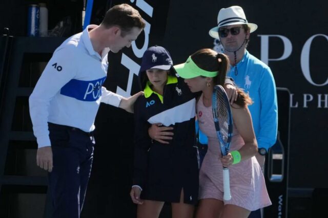 Zeynep Sonmez da Turquia e o árbitro Chase Urban ajudam um garoto que desmaiou na quadra durante sua partida de primeira rodada contra Ekaterina Alexandrova da Rússia no campeonato de tênis do Aberto da Austrália em Melbourne, Austrália, em 18 de janeiro de 2026. 