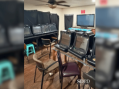 A polícia de San Diego invade uma operação de jogo ilegal em uma casa em City Heights A polícia de San Diego invade uma operação de jogo ilegal em uma casa em City Heights. Uma pequena sala com várias máquinas de jogo estilo caça-níqueis alinhadas em mesas, cadeiras espalhadas e cortinas pretas cobrindo as janelas.