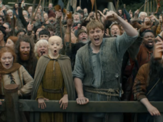 A prévia do episódio 3 do Cavaleiro dos Sete Reinos provoca o início do torneio Um homem e um menino estão diante de uma grande multidão, aplaudindo.