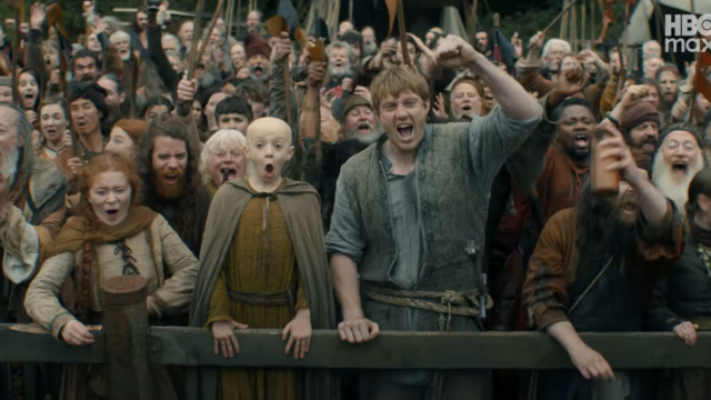 Um homem e um menino estão diante de uma grande multidão, aplaudindo.