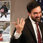 Uma mulher e uma criança caminham pela neve na 3ª Avenida.