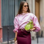 Alba Garavito Torre usa óculos de sol pretos da Ray Ban, brincos grandes com pingente dourado e branco, uma camiseta preta, um pulôver de lã branco com listras pretas da Massimo Dutti, uma bolsa de ombro Timeless de couro granulado preto brilhante da Chanel, uma jaqueta blazer oversized preta da Munthe, calça jeans skinny branca da Zara, couro bege brilhante com biqueira preta da Chanel, durante uma sessão de fotos de moda street style, em 29 de abril de 2023 em Paris, França.